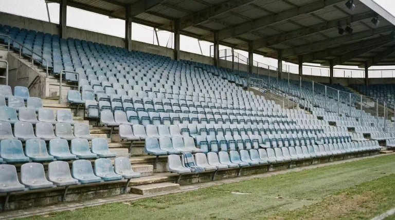 Descenso en la Premier League: grada vacía de estadio inglés con asientos desgastados y luz tenue