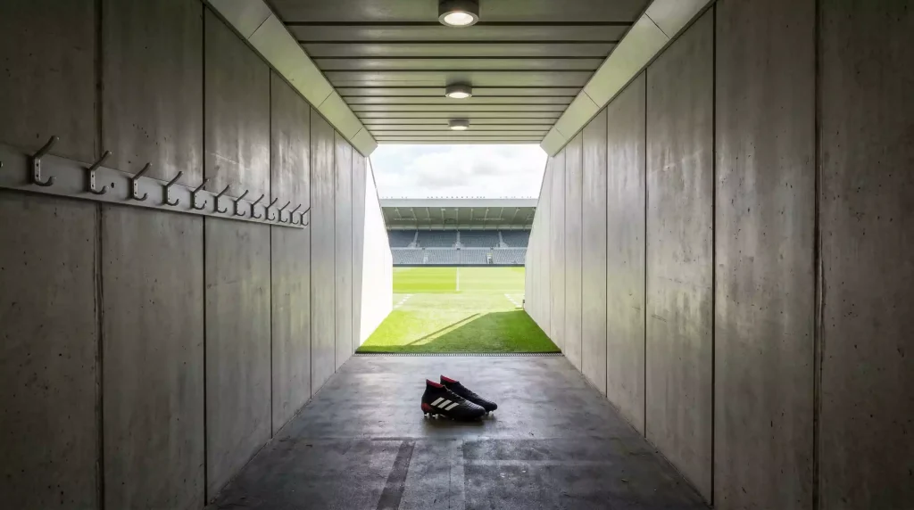 Fichajes récord de la Premier League: túnel de vestuarios de estadio de fútbol inglés con luz al fondo