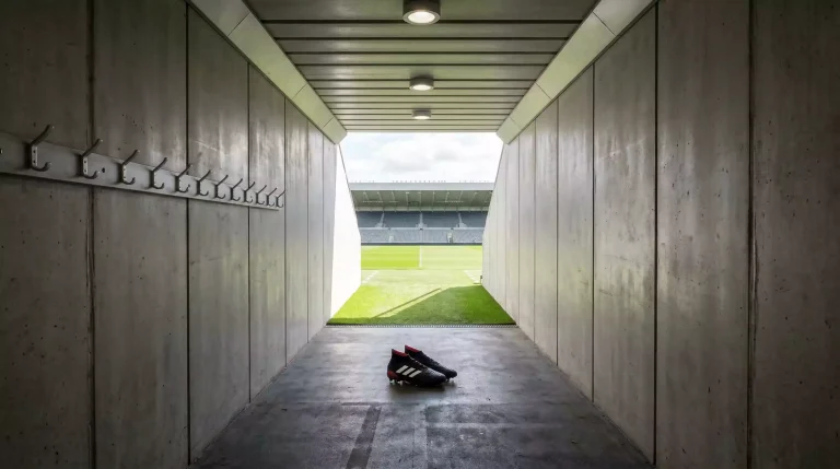 Fichajes récord de la Premier League: túnel de vestuarios de estadio de fútbol inglés con luz al fondo