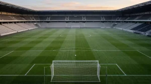Premier League vs La Liga: dos mitades de campo de fútbol unidas, césped verde bajo focos de estadio
